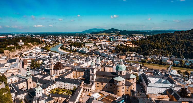Vista aérea del casco antiguo de Salzburgo con el río Salzach serpenteando a través de colinas verdes que lo rodean