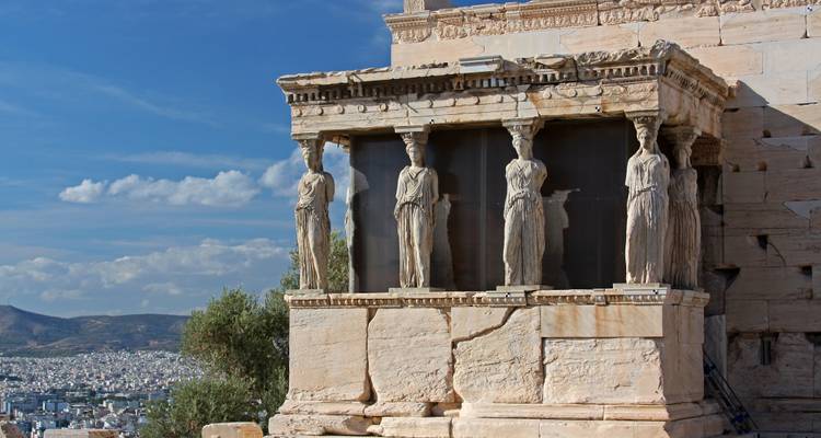 De Portiek van de Caryatiden met uitzicht op Athene onder heldere lucht.