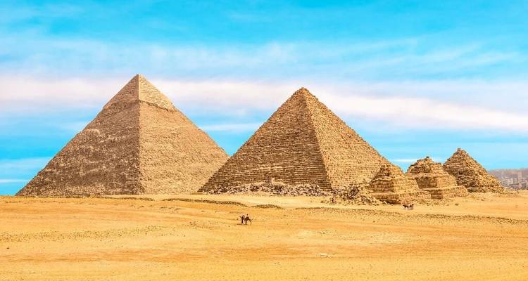 Drie Grote Piramides van Giza die uitsteken boven de gouden woestijn onder een heldere hemel