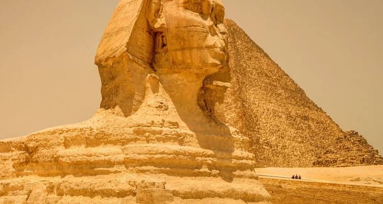 Profiel van de Grote Sfinx met de piramide van Khafre op de achtergrond in warme woestijnmist