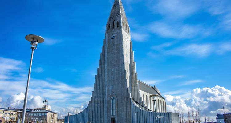 L'emblématique église Hallgrímskirkja s'élevant sous un ciel islandais d'un bleu éclatant.