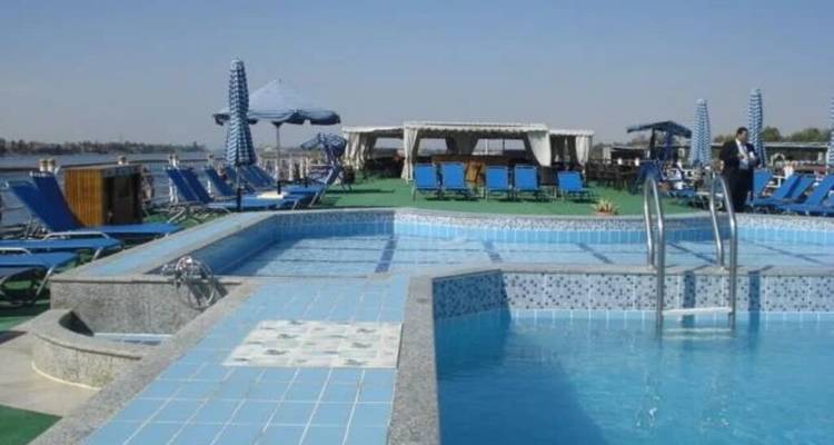 Daktuin zwembad op een riviercruiseschip met blauwe ligbedden onder een helderblauwe lucht.