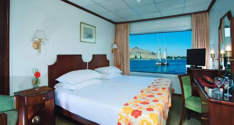 Cruise-cabin slaapkamer met raam met uitzicht op zeilboten op de Nijl.