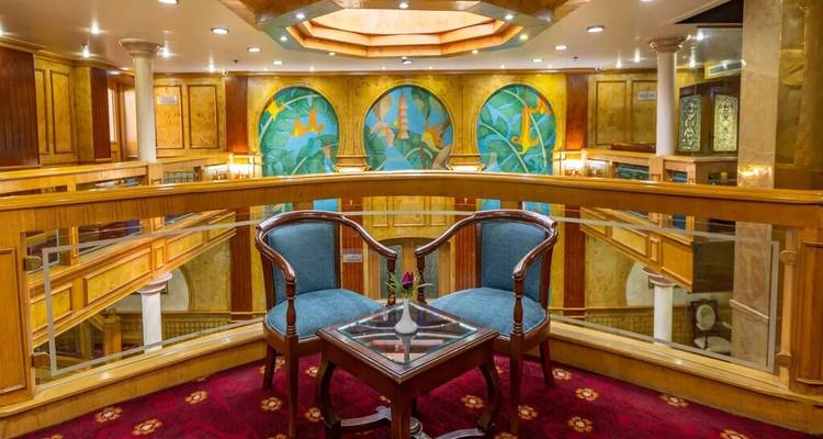 Elegante binnenkamer met twee fauteuils, glazen balustrade en kleurrijke muurschilderingen met zeethema