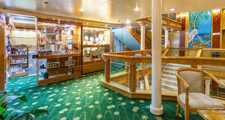 Interieur gang met een glazen winkelruimte waar souvenirs worden verkocht aan boord van een schip