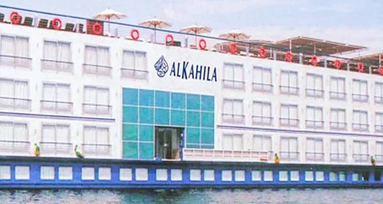 Buitenaanzicht van het witte riviercruiseschip genaamd 'ALKAHILA' dat op het water drijft