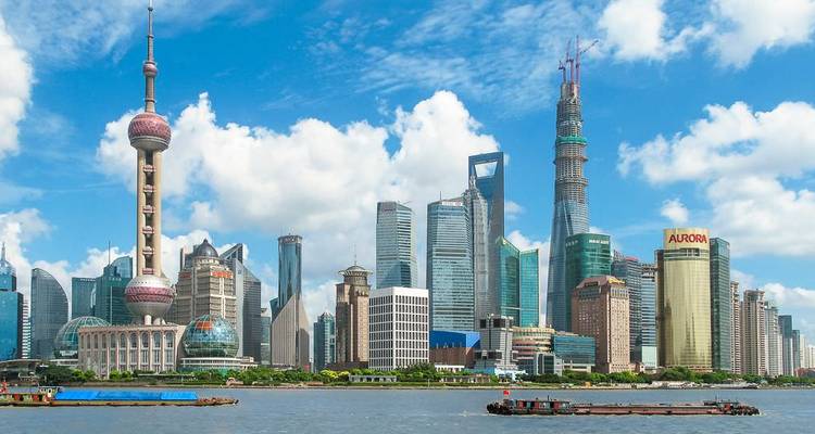 Ikonische Skyline von Shanghai Pudong mit dem Oriental Pearl Tower und Wolkenkratzern unter strahlend hellen Wolken