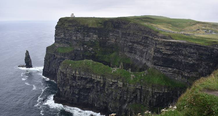 Des falaises vertigineuses surplombant l'océan Atlantique avec des vagues s'écrasant en contrebas aux Falaises de Moher