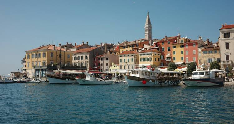 Farbenfrohe venezianisch geprägte Uferpromenade von Rovinj mit vertäuten Booten auf türkisfarbenem Wasser
