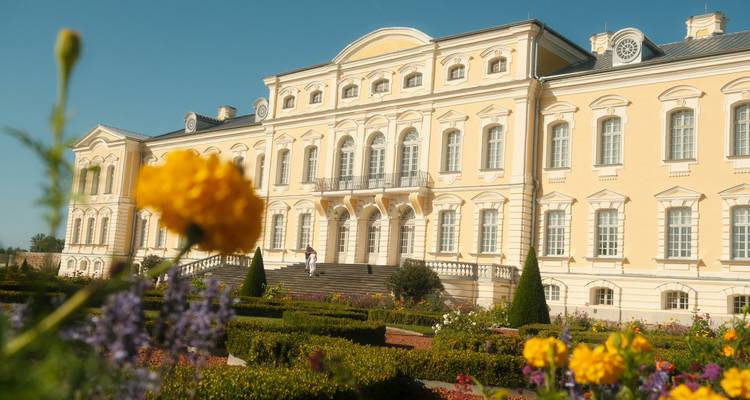 Elegantes gelbes barockes Schloss Rundale mit gepflegten Gärten und blühenden Blumen