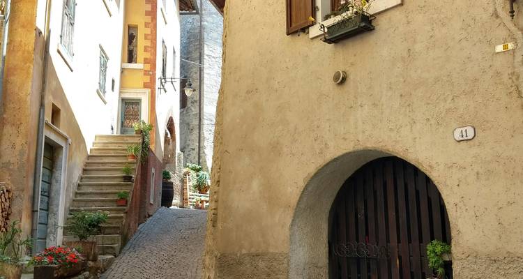 Enge Gasse mit Kopfsteinpflaster, Steinbögen, Treppen und Blumenkübeln
