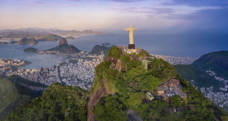 Luftaufnahme des Christus der Erlöser auf dem üppigen Berg Corcovado mit Blick auf Rios Küstenlinie und den Zuckerhut.
