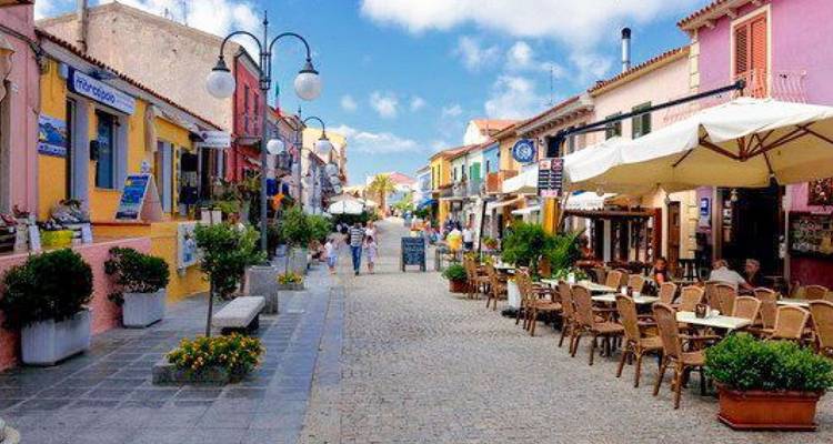 Charmante rue piétonne pavée de galets bordée de cafés et de boutiques sardes colorés