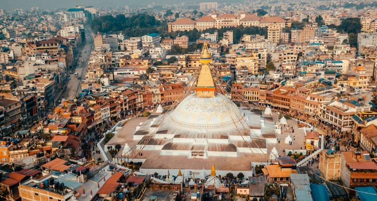 Vista aérea del Boudhanath Stupa de cúpula blanca rodeado por edificios densamente empaquetados de Katmandú.