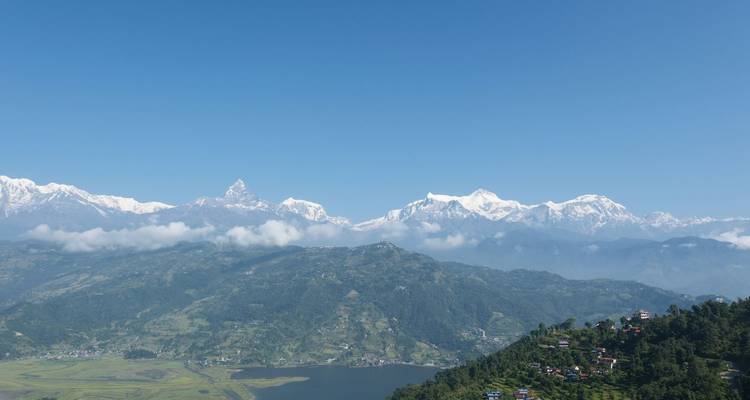 Vista panorámica de la cordillera del Annapurna sobre el valle de Pokhara y el lago Phewa bajo un cielo despejado.