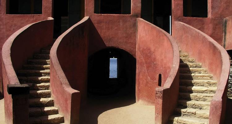 Les escaliers en double spirale menant à une porte sombre dans la Maison historique des Esclaves