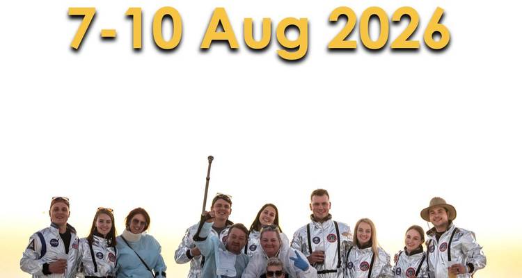 Group of people in novelty space suits posing under large promotional date text.