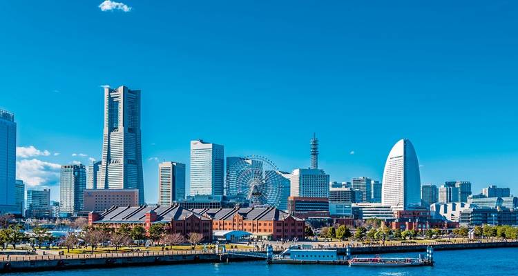 Klare Tagsüber-Skyline von Yokohama mit dem Landmark Tower, dem Riesenrad Cosmo Clock 21 und dem segelförmigen InterContinental-Hotel am Hafen.