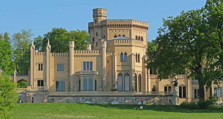 Le château de Babelsberg de style néo-gothique entouré d'un parc verdoyant lors d'un après-midi ensoleillé.