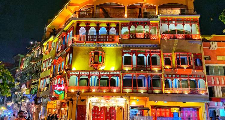 Edificio histórico iluminado vibrantly en la Calle de Comida de Lahore brillando con ventanas multicolores por la noche.