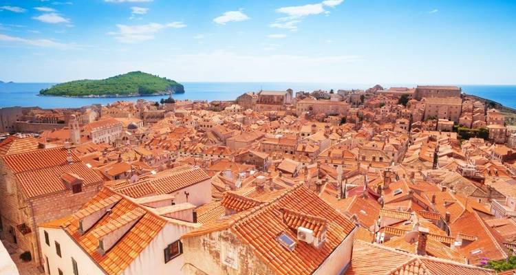 Los tejados de terracota del casco antiguo de Dubrovnik se extienden hacia el Adriático con la verde isla de Lokrum más allá.