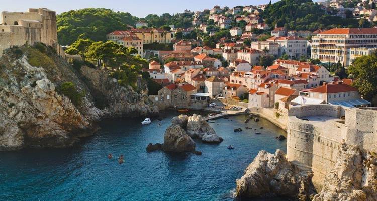 Una cala rocosa y fortificaciones medievales protegen un pequeño puerto al lado de las murallas de la ciudad vieja de Dubrovnik.
