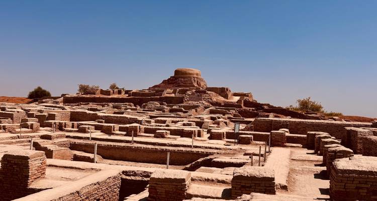 Les ruines de briques anciennes du site archéologique de Mohenjo-daro sous un ciel désertique bleu.