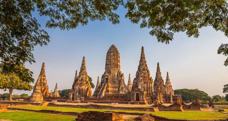 Großartige Ruinen des Tempelkomplexes Wat Chaiwatthanaram, umrahmt von Bäumen in Ayutthaya