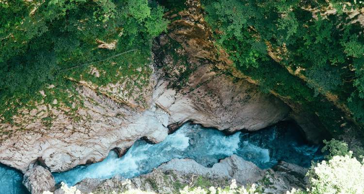 Wildwasser-Stromschnellen, die durch eine raue Kalksteinschlucht mit dichter Vegetation schneiden
