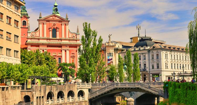 Warmfarbige Ansicht des historischen Zentrums von Ljubljana und der Dreifachbrücke im Nachmittagslicht