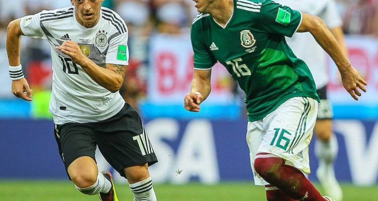 Foto de acción de jugadores de Alemania vs México corriendo a toda velocidad con el balón durante el partido de la Copa Mundial.