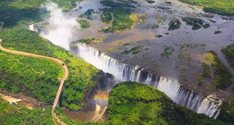 Luftaufnahme des Panoramas der Viktoriafälle und des Zambezi-Flusses mit Regenbogen im Nebel