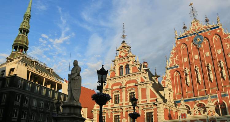 Ornates Schwarzhäupterhaus und benachbarte Spitzen gegen einen blauen Himmel in Rigas Altstadt