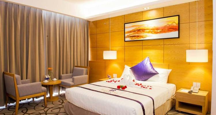 Gemütliches Hotelzimmer mit Rosenblättern dekoriert, warmer Beleuchtung und Holzpaneelwänden.