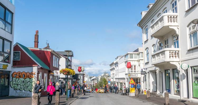 Rue piétonnière brillante flanquée de bâtiments nordiques blancs et rouges à Reykjavik