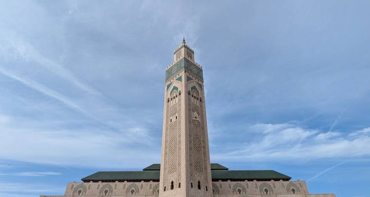 El imponente minarete de la Mezquita Hassan II enmarcado contra un cielo azul en Casablanca.