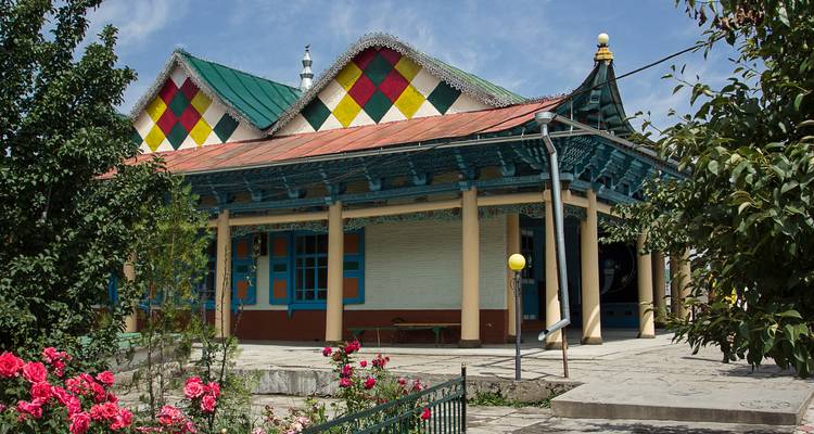 Colorida Mezquita Dungan de madera con techo de patrón de diamantes rodeada de jardines en Karakol