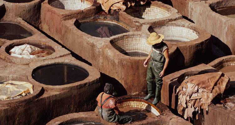 Trabajadores de pie en cubas circulares en la famosa curtidoría de cuero Chouara en Fes