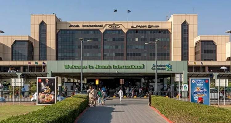 Gevel van Karachis Jinnah International Airport met mensen en taxi's ervoor.