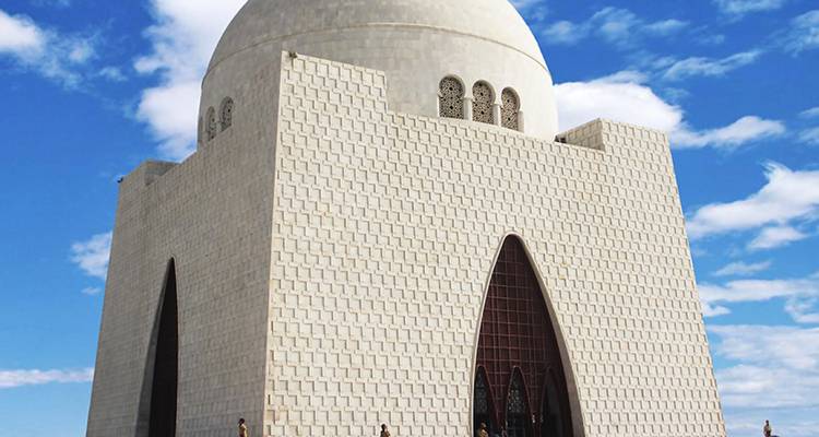 Witte marmeren Mazar-e-Quaid mausoleum tegen blauwe lucht met bezoekers aan de voet.