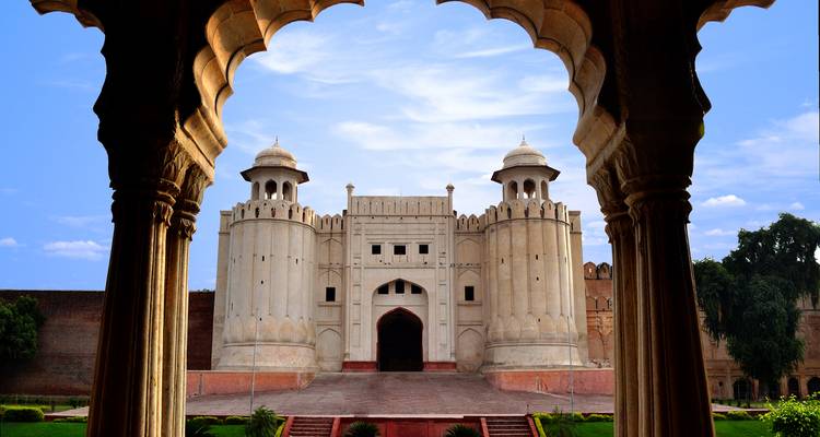 Iconische witte poort van het Lahore Fort omlijst door een Mughal-boog met verzorgde gazons.