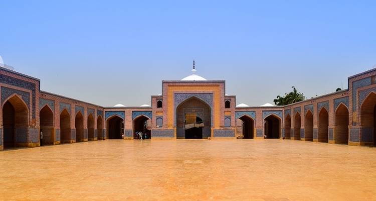 Uitgestrekte binnenplaats van de Shah Jahan moskee met ingewikkelde blauwe tegelgewelven.