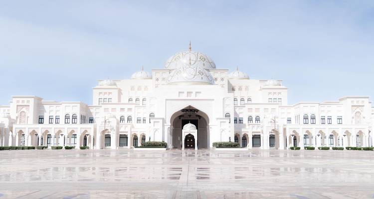 Grand palais blanc en marbre de Qasr Al Watan se reflétant sur une vaste cour.