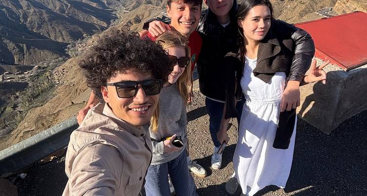 Groepsfoto op een bergpasspas met uitgestrekte ruige valleien op de achtergrond