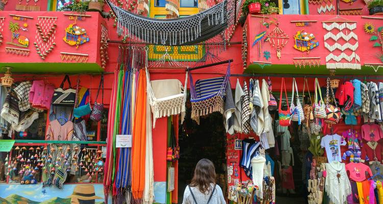 Boutique artisanale aux couleurs vibrantes à Ráquira présentant des hamacs, des textiles et de l'artisanat local tandis qu'un visiteur parcourt les produits.