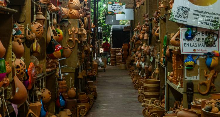 Une ruelle étroite bordée de rangées de poteries en terre cuite faites à la main dans un marché en plein air.