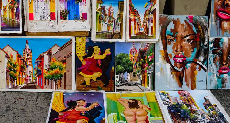 Étalage de vendeur ambulant présentant des œuvres d'art colombiennes éclatantes et des peintures colorées exposées à la vente.