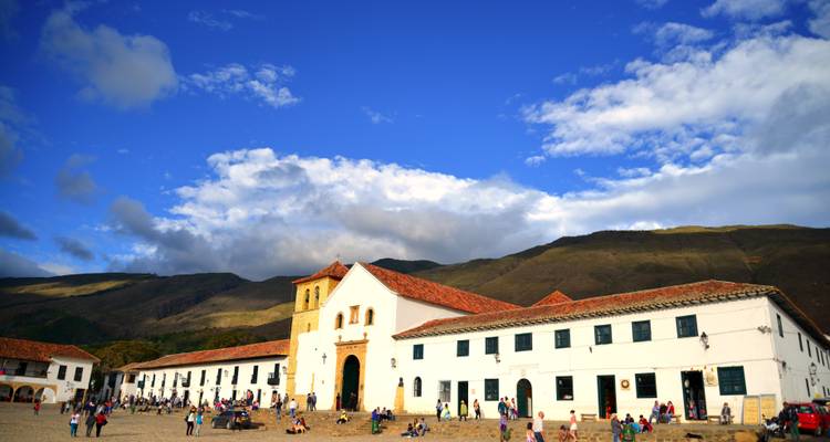 Les visiteurs se rassemblent sur la grande place principale de Villa de Leyva encadrée par les montagnes et des nuages spectaculaires.