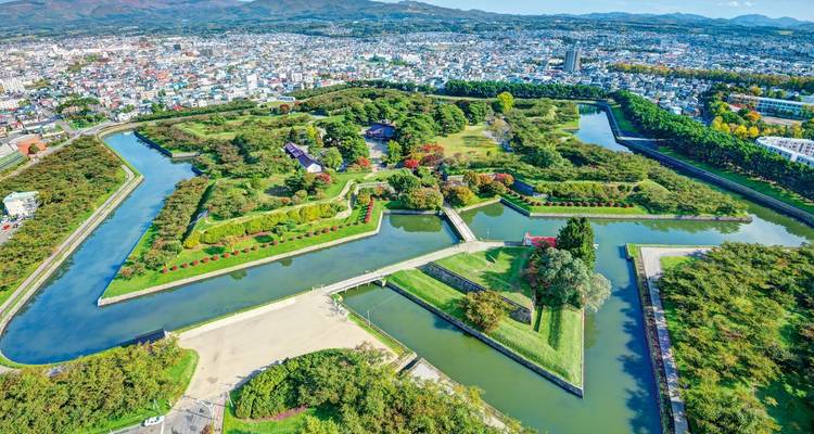 Luftaufnahme des sternförmigen Goryokaku-Forts, das von Gräben und Herbstbäumen in Hakodate umgeben ist.