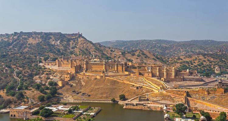Vista panorámica aérea del Fuerte Ámbar extendido sobre colinas escarpadas con un lago abajo.